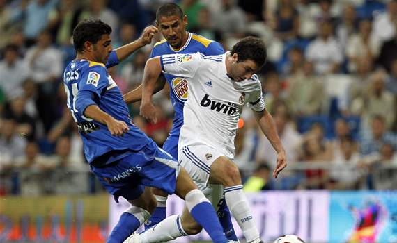 Gonzalo Higua&iacute;n se lleva el bal&oacute;n ante la marca de Miguel Torres y Cata Diaz, durante el Real Madrid-Getafe de la Liga BBVA