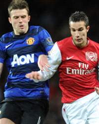 Robin van Persie of Arsenal takes on Michael Carrick