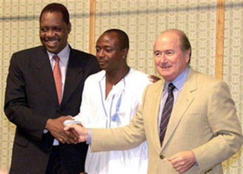 bedi Pele (C) shakes hands with FIFA President Joseph Sepp Blatter (R) and President of the African Soccer Federation Issa Hayatou