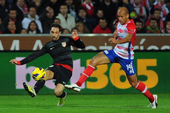 Atletico Madrid's midfielder Juanfran (L) vies for the ball Granada's midfielder Mikel Rico