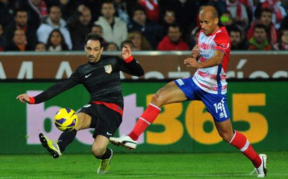 Atletico Madrid's midfielder Juanfran (L) vies for the ball Granada's midfielder Mikel Rico