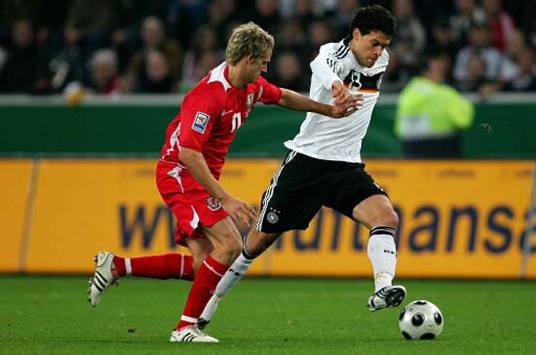 Michael Ballack, hier im Duell mit dem Waliser David Edwards, spielte trotz Wadenproblemen (firo)