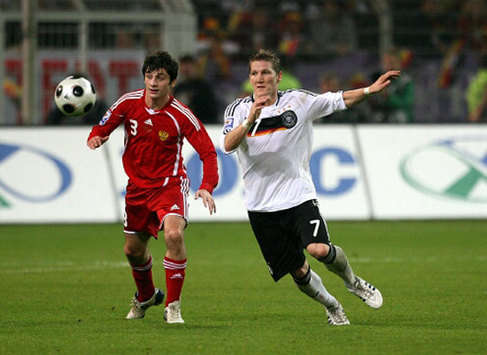 Russian international and Real Madrid target Dzagoev challenges Schweinsteiger of Germany