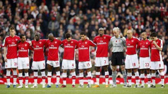 All as one: The Arsenal side that faced Manchester United line up before the clash to observe a minute's silence for British war heroes.