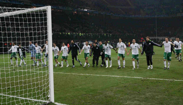 Panathinaikos players and coaches join hands in celebration of their Champions League win over Inter Milan.