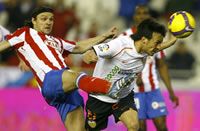 David Silva leads Tomas Ujfalusi to the ball in Valencia's win over Atletico Madrid.