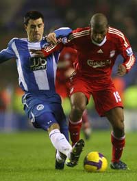 Liverpool's Ryan Babel fights Wigan's Paul Scharner for possession
