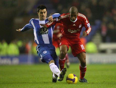 Liverpool's Ryan Babel fights Wigan's Paul Scharner for possession