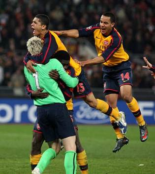 Arsenal players run towards Manuel Almunia after Roma missed their penalty in sudden death