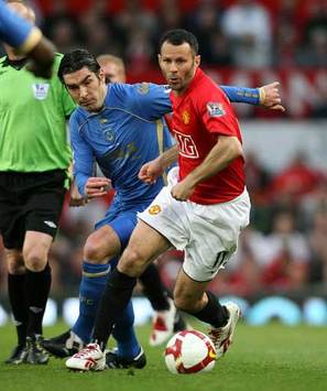 Manchester United winger Ryan Giggs in action against Portsmouth's Richard Hughes at Old Trafford