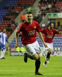 Michael Carrick grabs the winner for Manchester United against Wigan Athletic to send his side within a point of the title