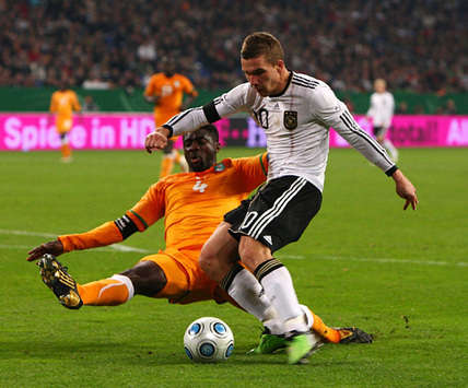 Lukas Podolski setzt sich gegen Kolo Toure durch, trifft zum späten Ausgleich gegen die Elfenbeinküste (Bongarts/Getty Images)