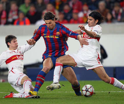 Zlatan Ibrahimovic struggles to hold off the challenge of two Stuttgart defenders